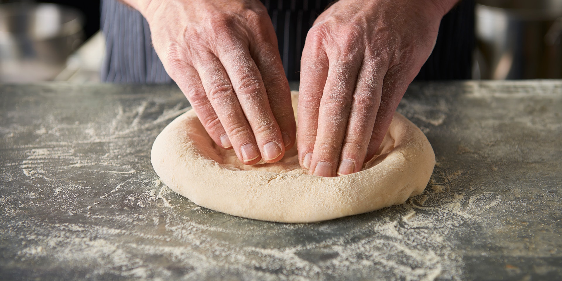 hands kneading pizza dough