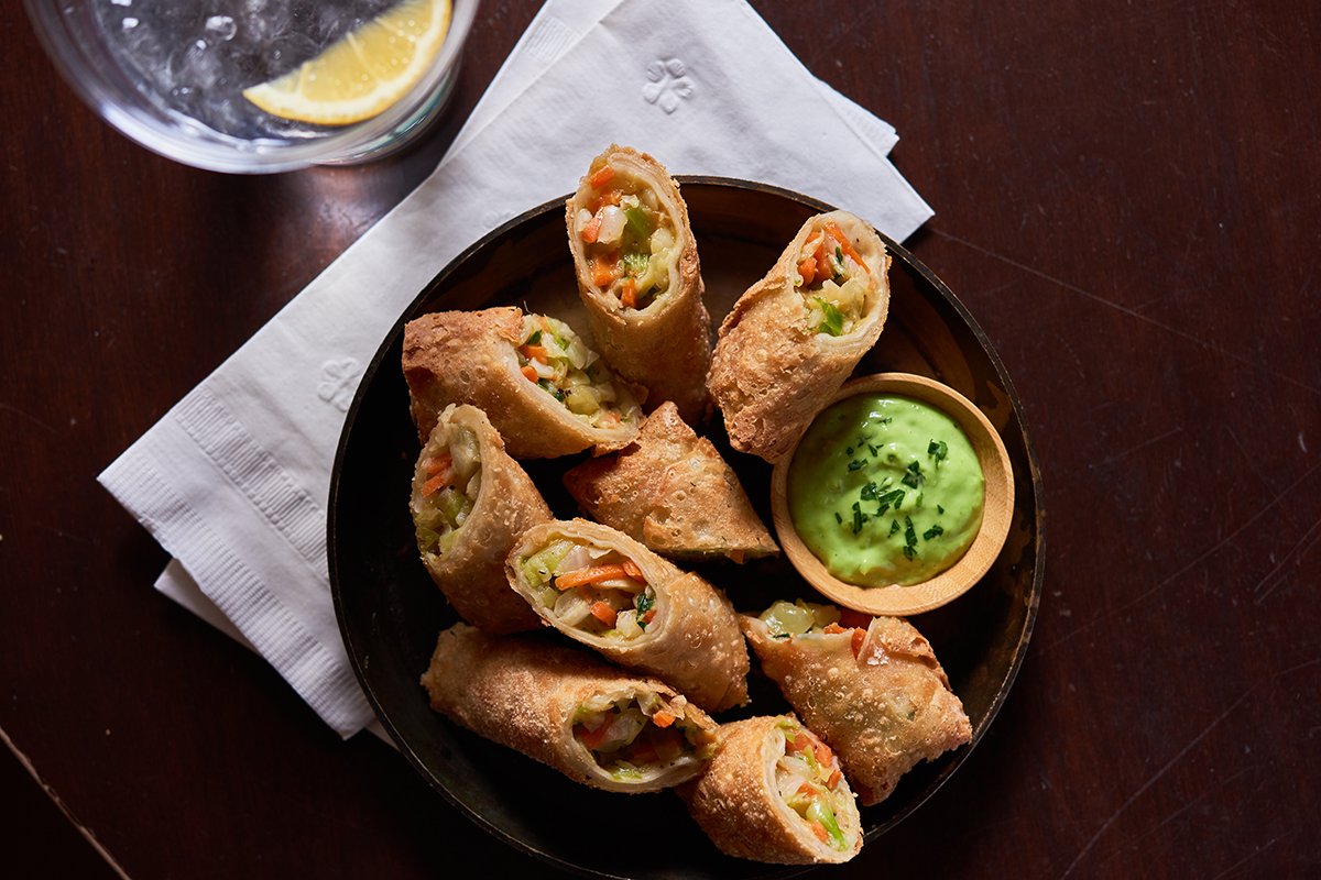 egg rolls served with a green sauce